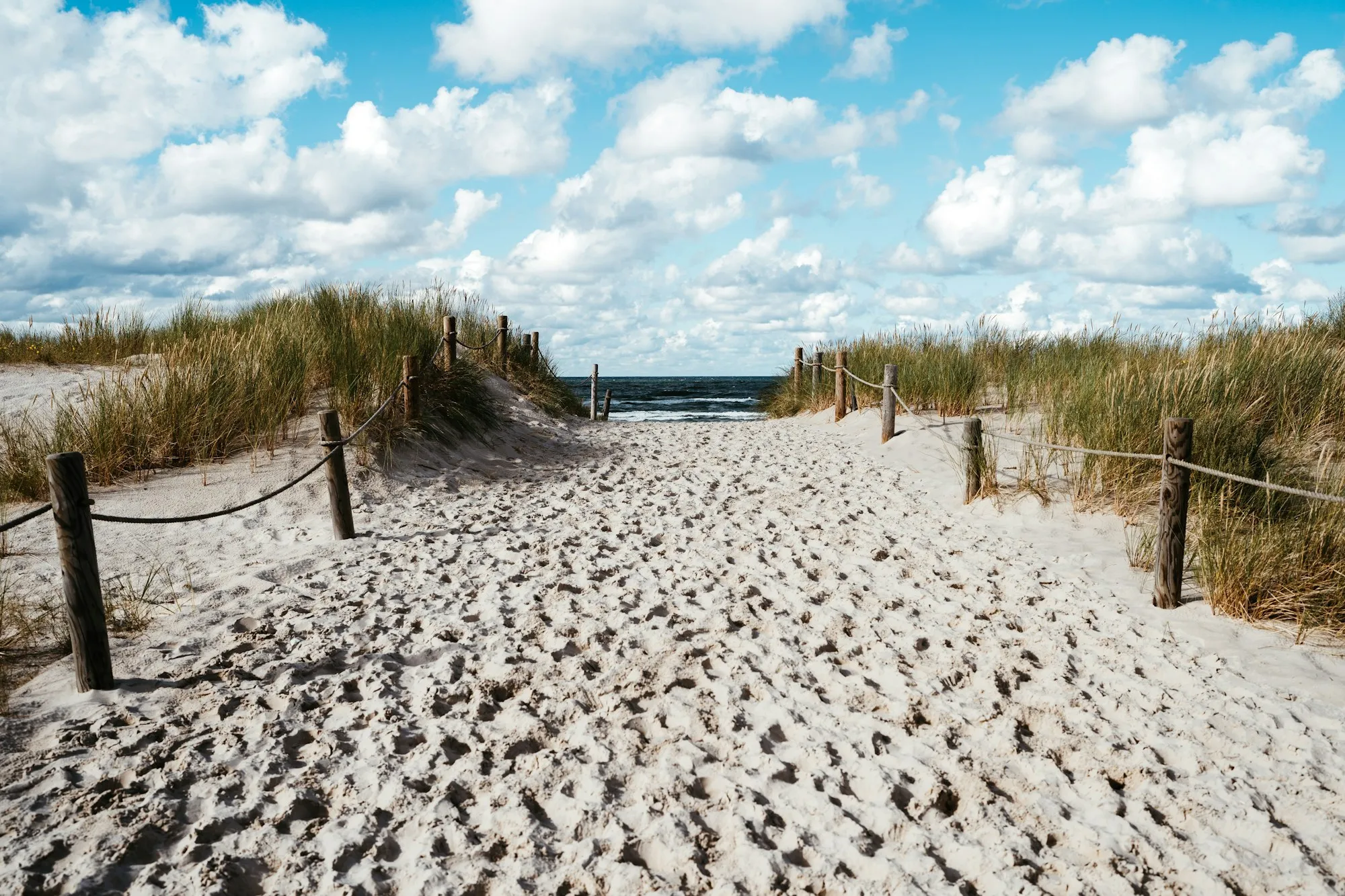 Piaszczyste zejście na plażę przez wydmy